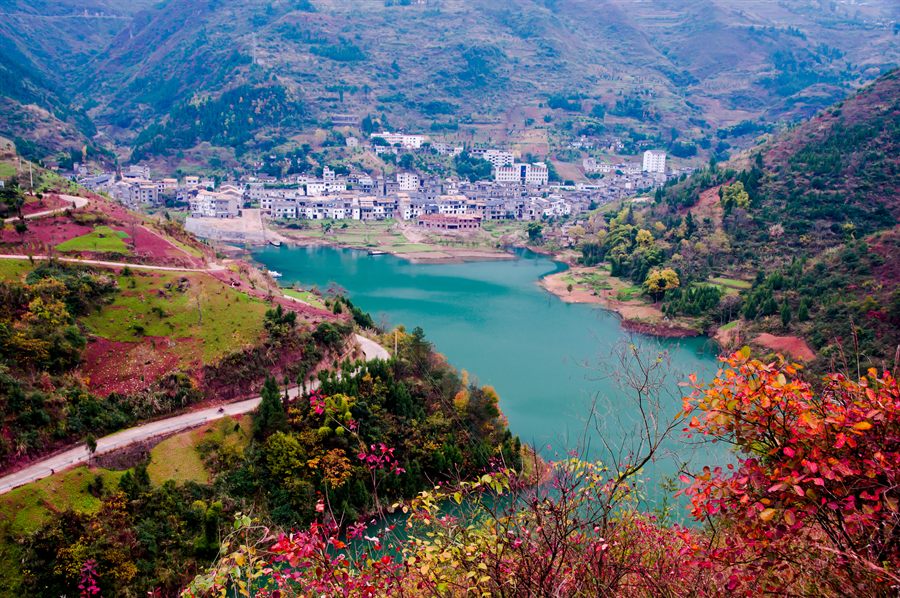 Turquoise river bend below a hillside town in the Yangtze gorges country